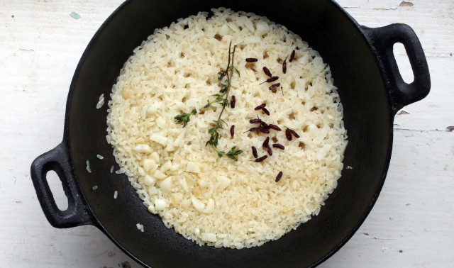 A bowl of fluffy white rice, sprinkled with black beans